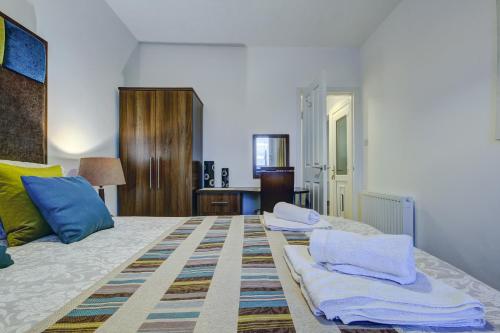 a bedroom with a bed with towels on it at Garden Gate Upper Apartment in Prestwick