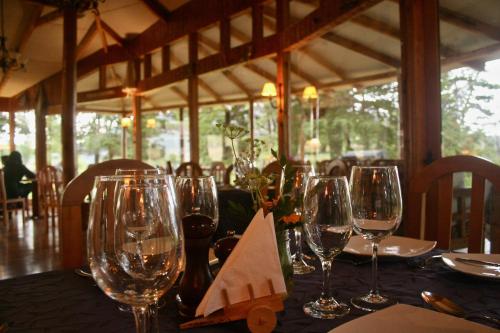 a table with wine glasses on top of it at Lodge El Mirador De Guadal in Puerto Guadal