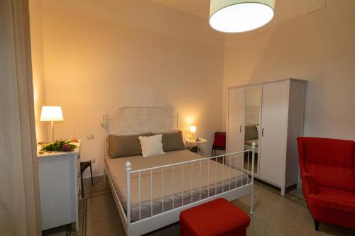 1 dormitorio con 1 cama y 1 silla roja en Sichelgaita Apartment, en Salerno