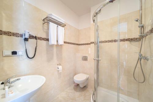 a bathroom with a shower and a toilet and a sink at Pokoje Fregata in Mikołajki