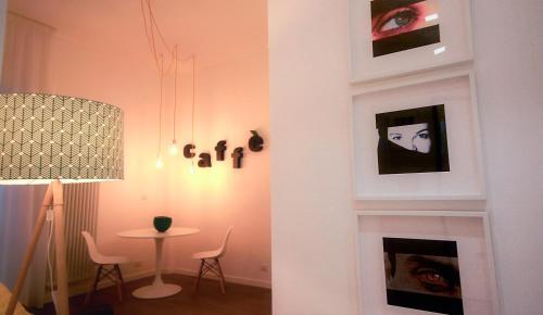 Albero della fortuna في تورينو: غرفة معيشة مع طاولة وجدار بالصور