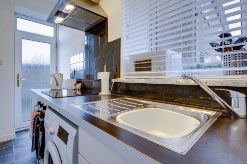 a kitchen with a sink and a large window at Apartment Caerlaverock Road in Prestwick