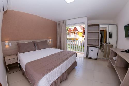 a bedroom with a large bed and a balcony at Apartamento China Park in Domingos Martins