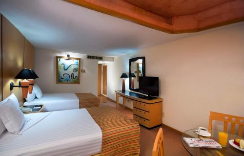 瓜達拉哈拉的住宿－Hotel Guadalajara Plaza Ejecutivo，酒店客房设有两张床和电视。