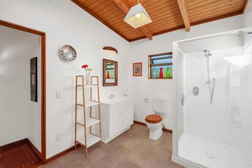 a bathroom with a shower and a toilet and a sink at Treetop Hideaway - Taupo Holiday Home in Taupo