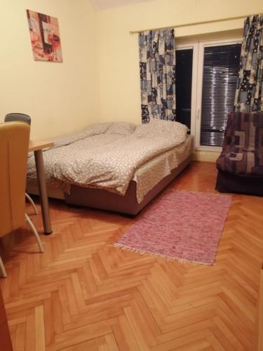 a bedroom with a bed and a table and a window at Apartman Zlatibor Dimitrije in Zlatibor