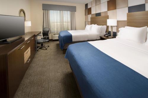 a hotel room with two beds and a flat screen tv at Holiday Inn Express Hotel & Suites Waco South by IHG in Waco
