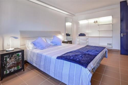 een slaapkamer met een groot bed met blauwe kussens bij vista oceano, confortevole, ampio, gran terrazza, Wi-Fi in Costa Calma