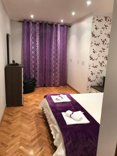 1 dormitorio con cortinas moradas y 1 cama con 2 toallas en Apartamento turístico iguazu, en Ribadeo
