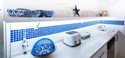 a kitchen counter with a sink and blue and white vases at Sandy Lodge, 4 Porters Court in Saint James