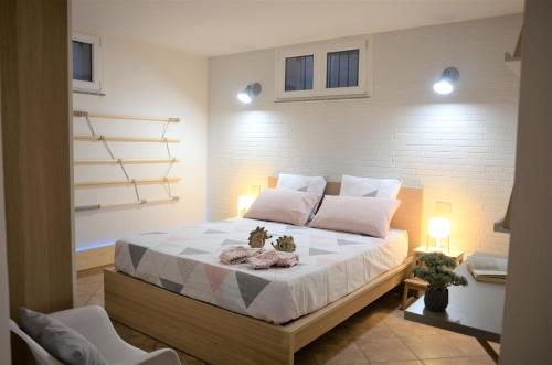 a bedroom with a large bed with two plants on it at Murdegus Maison - Vivi il tuo Sogno in Sardegna! in Tortolì