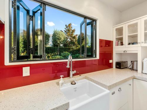 a kitchen with a sink and a large window at Willowridge Escape - Wanaka Holiday Home in Wanaka
