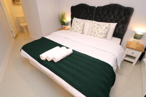 a bedroom with a large bed with two towels on it at The Spinney in Bracknell