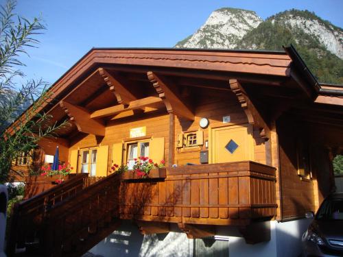 a log cabin with a porch and mountains in the background at Alpen-Chalets Achensee in Maurach
