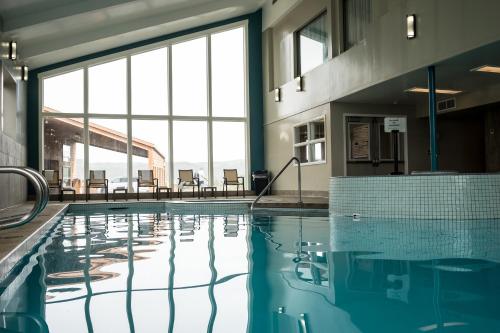 a swimming pool with tables and chairs in a building at Hallmark Resort in Cannon Beach in Cannon Beach
