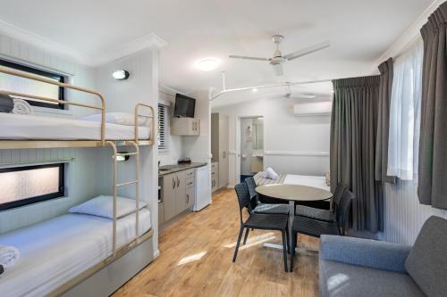 a small room with bunk beds and a table at Ingenia Holidays Cairns Coconut in Cairns
