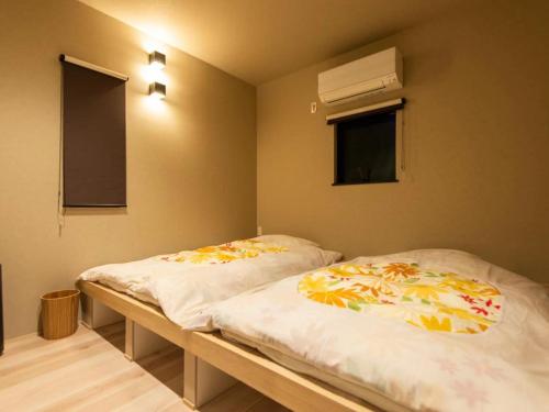 福岡市にあるSYA Hotel-上呉服町 一軒家貸し切りの窓のある部屋にツインベッドが2台