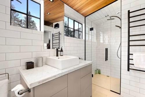 a white bathroom with a sink and a shower at Wanaka Stone Cottage - Wanaka Holiday Home in Wanaka
