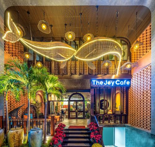 a lobby of a luxury hotel with palm trees and a sign at Seahorse Tropical Da Nang Hotel by Haviland in Da Nang