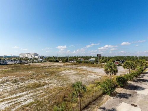 an empty parking lot with palm trees and a building at Sugar Beach in Gulf Shores