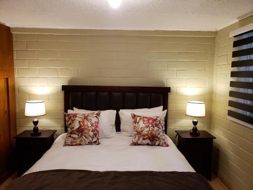 - une chambre avec un lit avec des oreillers et 2 lampes dans l'établissement Casa Ohiggins, à La Calera