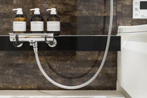 three bottles of wine on a hose in a bathroom at Kyo no yado en in Kyoto