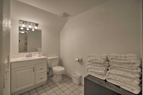 a bathroom with a sink and a toilet and towels at South Padre Island Oasis with Pool Walk to Beach! in South Padre Island