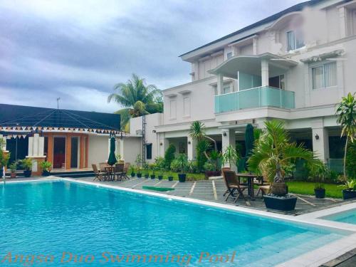 a swimming pool in front of a building at KAWANA HOTEL in Kampungdurian