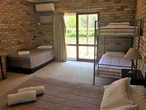 斯托尔Magdala Motor Lodge & Lakeside Restaurant的一间卧室，有两张双层床和一扇窗户