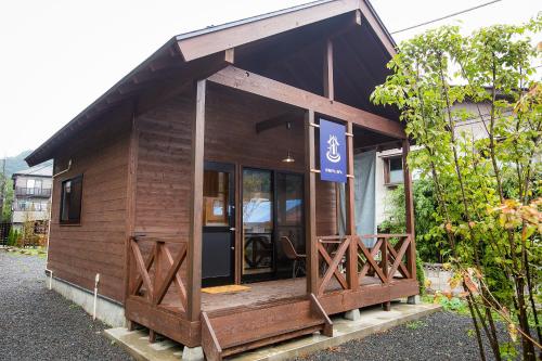 a small wooden building with a sign on it at SHIOYA SPA in Minakami