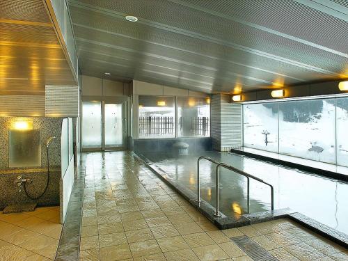 a swimming pool in a large building with a pool at New Greenpia Tsunan in Tsunan