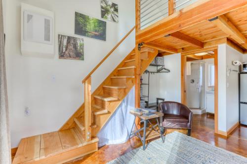 a wooden staircase in a living room with a chair at Sequoia Cottage in Eureka