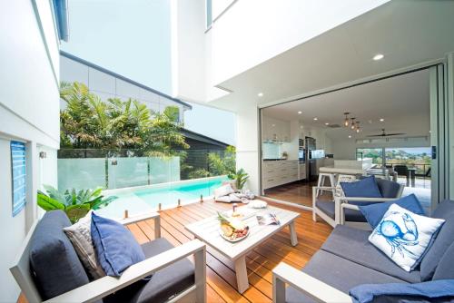 an open living room with a pool and a house at Oleander Holiday Home - Airlie Beach in Airlie Beach