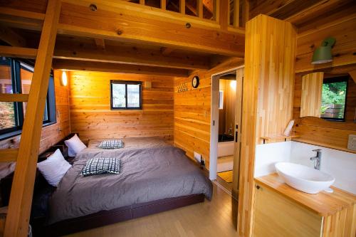 みなかみ町にある塩屋温泉　SHIOYA SPAのログキャビン内のベッドルーム(ベッド1台、シンク付)
