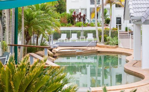a swimming pool in the middle of a building with palm trees at The Bay Apartments Coolangatta in Gold Coast