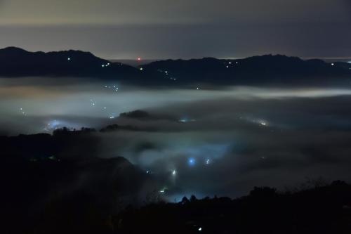 a view of a foggy valley at night with lights at Maple map B&B in Dahu