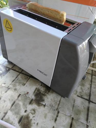 a toaster oven with a loaf of bread on top at Bonda Guesthouse I in Paka