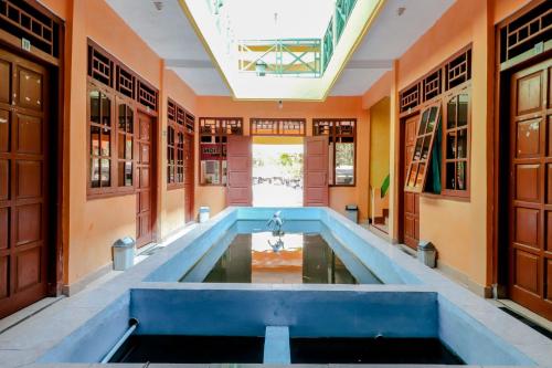 una piscina cubierta en una habitación con paredes de color naranja en Hotel Kukup Indah, en Kemadang