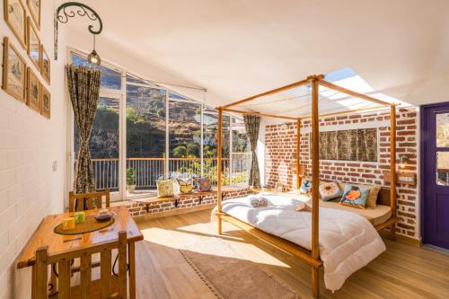 a bedroom with a canopy bed and a table at Zostel Plus Mussoorie- Kempty in Mussoorie
