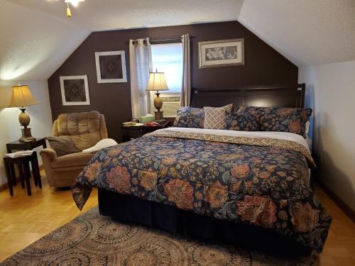 Blue Ridge Manor Bed and Breakfast في Fancy Gap: غرفة نوم بسرير كنج وكرسي