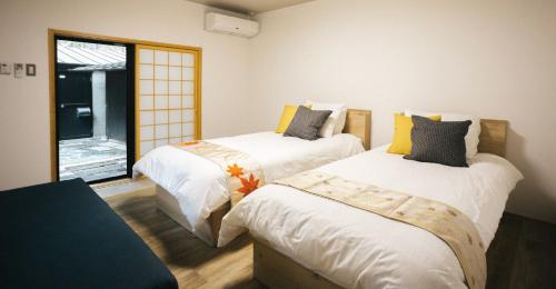 1 dormitorio con 2 camas y ventana en Miyajima Shiro, en Miyajima