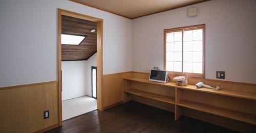 a room with a window and a desk with a television at Miyajima Shiro in Miyajima