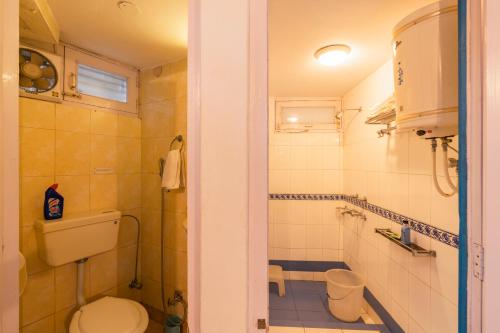 a bathroom with a toilet and a shower at Zostel Plus Mussoorie- Kempty in Mussoorie