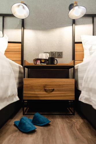 two blue slippers on the floor in a bedroom with two beds at SVOK Hotel in Tawau