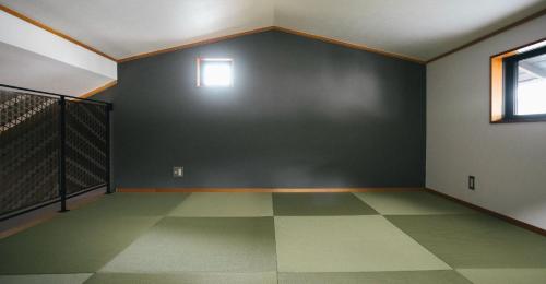 an empty room with a green wall and a window at Miyajima Shiro in Miyajima
