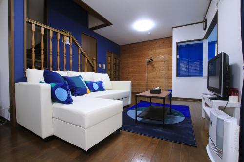 a living room with a white couch and a tv at Tiz wan 津名あわじ in Awaji