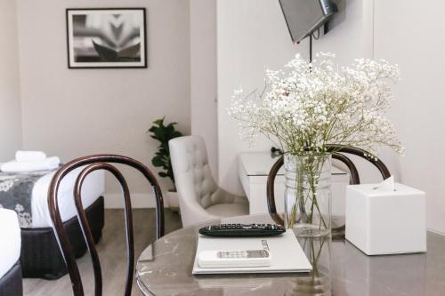 a living room with a glass table and two chairs at The Lurline Randwick in Sydney