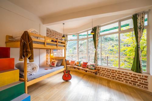 a bedroom with bunk beds and a large window at Zostel Plus Mussoorie- Kempty in Mussoorie