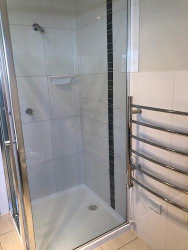 a shower with a glass door in a bathroom at Central executive 4br townhouse in Albury