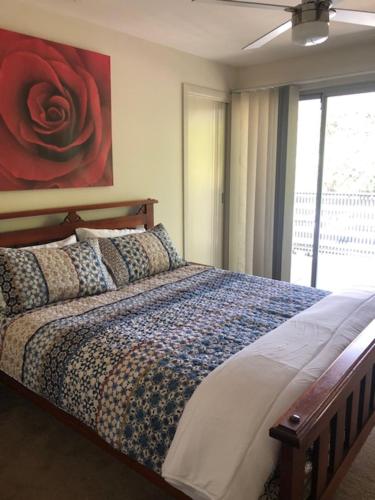 a bedroom with a bed with a red rose on the wall at Central executive 4br townhouse in Albury